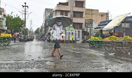 Beawar, Rajasthan, Indien, 24. Juli 2020: Fußgänger gehen bei starkem Regen auf einer Straße in Beawar. Kredit: Sumit Saraswat/Alamy Live Nachrichten Stockfoto