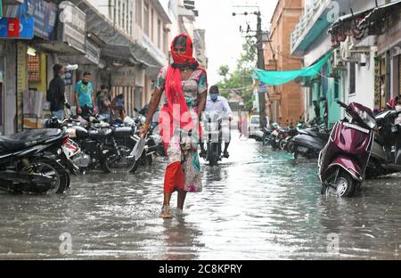 Beawar, Rajasthan, Indien, 24. Juli 2020: Fußgänger waten durch wassergeloggte Straße nach starkem Regen in Beawar. Kredit: Sumit Saraswat/Alamy Live Nachrichten Stockfoto