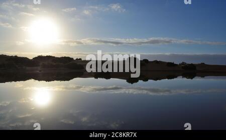 Herrlicher Sonnenaufgang mit Reflexen im Wasser, Charca de Maspalomas, Gran Canaria, Kanarische Inseln, Spanien Stockfoto