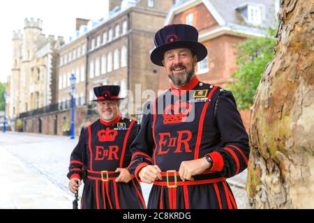 London, Großbritannien. Juli 2020. Zwei freundliche Beefeater, wie die Yeomen Warders of her Majesty's Royal Palace und Fortress the Tower of London sind allgemein bekannt, erwarten die Besucher mit einem freundlichen Lächeln und Informationen. Nach 4 Monaten der Schließung des Coronavirus, etwas, das in der Geschichte des Turms anscheinend noch nie geschehen ist, hat der Turm Anfang dieses Monats wieder eröffnet und bietet eine einzigartige Gelegenheit, seine historischen Gebäude zu besuchen und die Kronjuwelen ohne die üblichen langen Warteschlangen und Menschenmassen zu sehen. Kredit: Imageplotter/Alamy Live Nachrichten Stockfoto