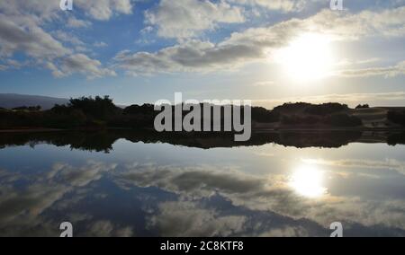 Ehrfürchtiges Sonnenaufgang mit schönen Reflexen im Wasser, Charca de Maspalomas, Kanarische Inseln, Spanien Stockfoto