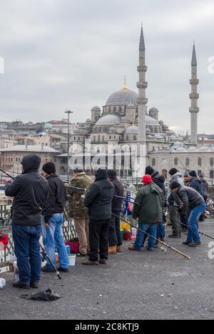 ISTANBUL, TÜRKEI - 02. JANUAR 2015: Fischer an einem bewölkten Januartag auf der Galata-Brücke Stockfoto