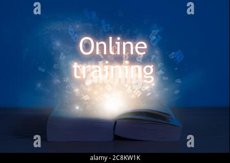 Online-Schulungskonzept. Licht kommt aus dem offenen Buch mit Wörtern Online-Training. Stockfoto