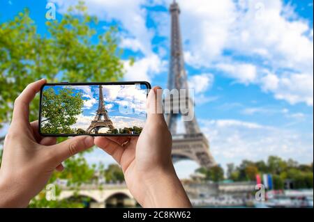 Tourist fotografieren Eiffelturm in Paris, Frankreich. Mann, der Telefon hält und fotografiert. Stockfoto