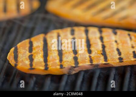 Scheiben Süßkartoffeln (Ipomoea batatas) werden auf dem Grill gegrillt Stockfoto