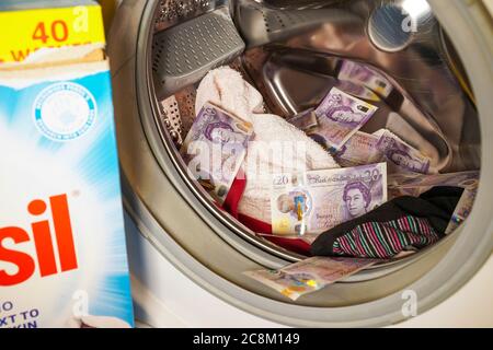 Nahaufnahme der britischen Währung, 20 Pfund-Noten, innen Trommel der automatischen Waschmaschine. Konzept Geldwäsche, Wäsche schmutziges Geld von Verbrechen. Stockfoto