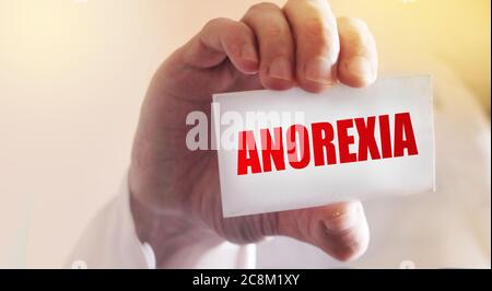 Arzt hält eine Karte mit dem Namen der Diagnose - Anorexie. Selektiver Fokus. Medizinisches Konzept Stockfoto