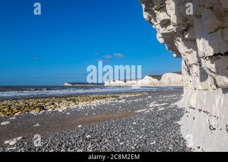 Blick entlang eines Kiesstrandes an der Sussex Küste auf die Seven Sisters Cliffs Stockfoto