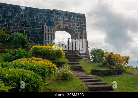 Blick auf die Steinmauern von Fort Frederick, einem alten karibischen Fort, zu den Bergen darunter. Stockfoto