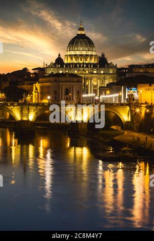 Die Lichter rund um den Vatikan und die Petersbasilika spiegeln sich im Tiber in Rom, Italien. Stockfoto