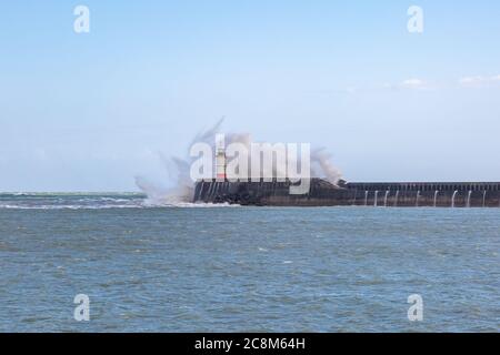 Wellen krachen über den Steg und um den Leuchtturm herum, bei Newhaven in Sussex Stockfoto