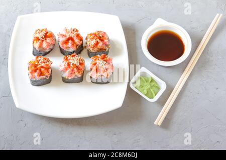 Japanisches Sushi mit Sojasauce und Wasabi mit Essstäbchen auf grauem Betongrund. Draufsicht Stockfoto