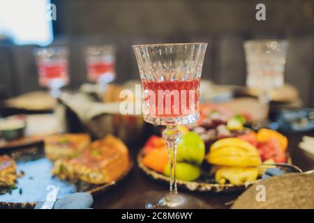 Konzentrieren Sie sich auf Hände Servieren Gerichte mit Fleisch und Gemüse an eine Gruppe von Freunden um einen Tisch auf einer Sommerterrasse versammelt. Stockfoto