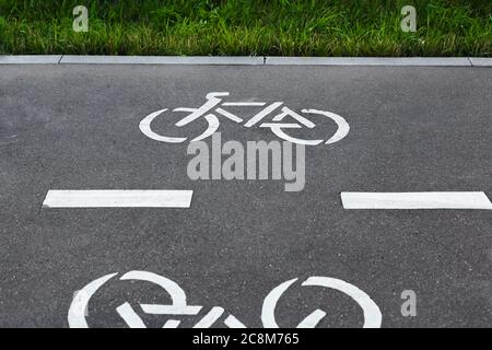 Fahrradweg Symbole auf dem Asphalt in einem Park. Fahrradschilder auf dem Fahrradweg Stockfoto