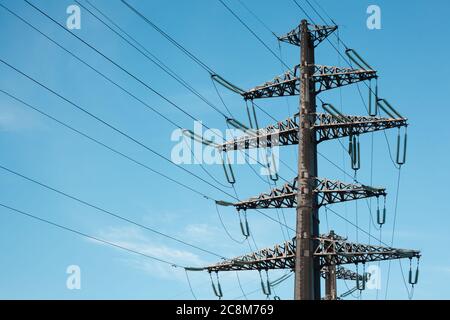 Stromübertragungsleitung gegen klaren blauen Himmel. Hochspannungsturm Stockfoto