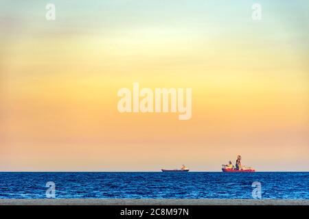 Schiffe am Horizont bei tropischem Sonnenuntergang am Copacabana Strand in Rio de Janeiro Stockfoto