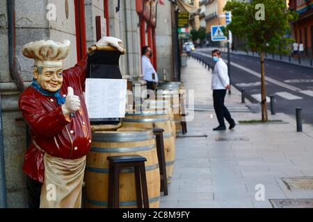 25th. Juli 2020, Calle Mayor, Madrid, Spanien: Kellner warten auf Kunden vor einem leeren Restaurant. Madrids Straßen und Cafés sind viel ruhiger, als sie normalerweise wären. Seit dem 21st. Juni hat Spanien nach einer strikten Sperre die Beschränkungen zur Bekämpfung des Covid 19-Coronavirus gelockert. Die britische Regierung hat heute angekündigt, dass Menschen, die aus Spanien zurückkehren, nach einer Zunahme der Zahl neuer kovidierter Infektionen nun in Quarantäne gehen müssen. Stockfoto