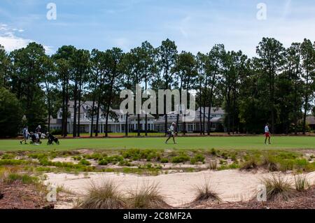 Dorf Pinehurst, North Carolina, USA. Juli 2020. Spieler und ihre Caddies gehen an einem der Herrenhäuser entlang des Kurses während der Finalrunde der US Kids Golf World Teen Championship (Boys 15-18) im berühmten Pinehurst No. 2, im Dorf Pinehurst, North Carolina, vorbei. Jedes Jahr begrüßt die World Teen Championship Golfer im Alter von 13Ã‘18 bis sieben Championship-Plätze in der Pinehurst Gegend. Diese Kurse, dieses Ereignis und die Gemeinschaft als Ganzes haben eine Bühne für golfÃs nächste Generation von Sternen zum Leuchten gebracht. Kredit: ZUMA Press, Inc./Alamy Live Nachrichten Stockfoto