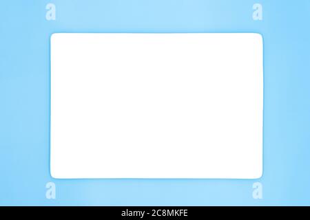 Eine leere, rechteckige weiße Platte, die auf dem hellblauen Hintergrund isoliert ist. Stockfoto