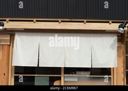Der Vorhang-ähnliche Stoff, der vor traditionellen japanischen Restaurants und Geschäften hängt, dient nicht nur als Schild, sondern hat eine größere Bedeutung, Stockfoto