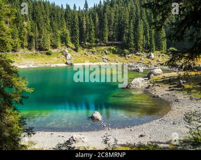 Der Karersee unterhalb des Karerpasses am Fuße des Latemarmassivs in Südtirol, Italien Stockfoto