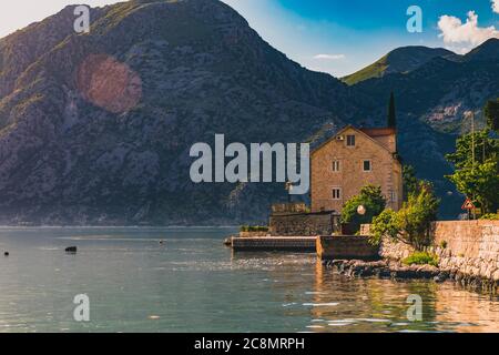 Blick auf die Bucht von Kotor oder Boka Kotorska mit Bergen, kristallklarem Wasser und einem alten Steinhaus auf dem Balkan, Montenegro an der Adria Stockfoto