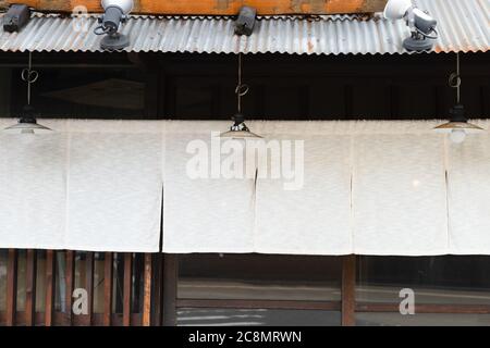 Der Vorhang-ähnliche Stoff, der vor traditionellen japanischen Restaurants und Geschäften hängt, dient nicht nur als Schild, sondern hat eine größere Bedeutung, Stockfoto