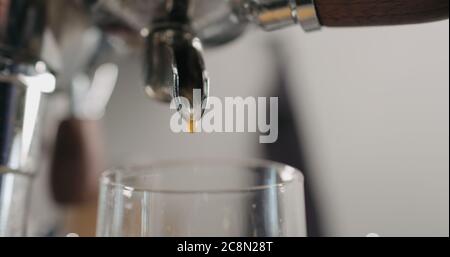 Niedriger Winkel Schuss Espresso gießen aus der Kaffeemaschine ingo Glasbecher Stockfoto