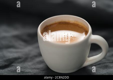 Heißer Espresso in weißer Tasse auf Leinentuch mit Kopie Platz Stockfoto