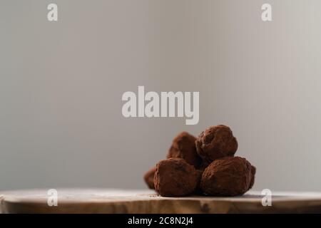 Handgemachte Schokoladentrüffel auf olivfarbenem Brett Stockfoto