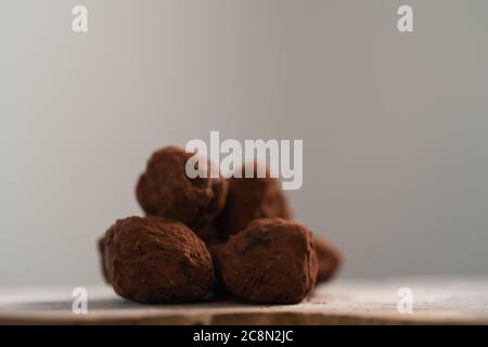Handgemachte Schokoladentrüffel auf olivfarbenem Brett Stockfoto