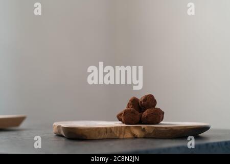 Handgemachte Schokoladentrüffel auf olivfarbenem Brett Stockfoto