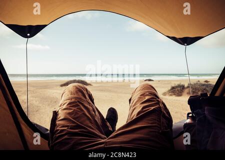 Entspannen Sie sich und genießen Sie Zelt Camping Sommerurlaub alternative Urlaub auf einem freien Wüste Strand Blick - unkenntlich Mann legen und genießen Sie in der winzigen t Stockfoto