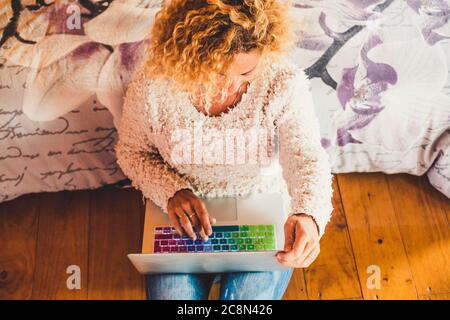 Glückliche Menschen arbeiten zu Hause oder im Hotelzimmer mit einem modernen Laptop-Computer und genießen die Freiheit vom Büro - Smart Working Concept und Business Shop Stockfoto