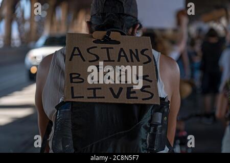 NEW YORK, NY – 25. JULI: Ein Protestler mit einem Schild, auf dem steht: „Asians for Black Lives“, fährt während eines marschfahrens über die Queensboro Bridge Stockfoto