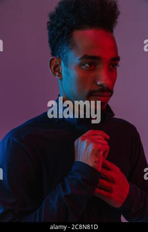 Portrait von Casual afrikanische amerikanische Mann in Sportswear poising an Kamera über violett Hintergrund isoliert Stockfoto