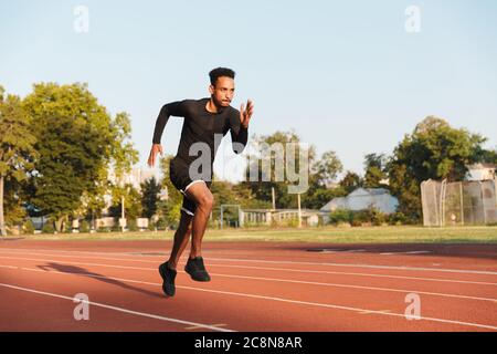 Bild des athletischen afrikanische amerikanische Mann laufen auf Sport Stadion im Freien Stockfoto