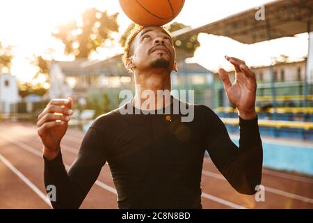 Image eines starken afrikanischen hübscher junger Mann bei Stadion im Freien Sport Basketball zu spielen. Stockfoto
