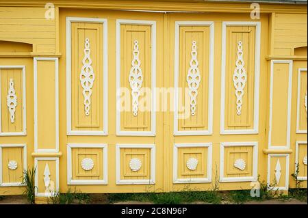 Hölzerne breite Tore in alten russischen Häusern. Figurative Ornamente aus Holz.Helle Farben. Alte russische Holzhäuser. Stockfoto