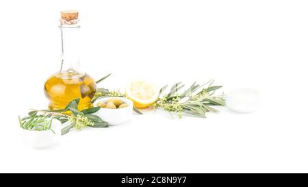 Glasflasche mit nativem Olivenöl Premium, Zitrone und einige Oliven mit Olivenzweig isoliert auf weißem Hintergrund. Stockfoto