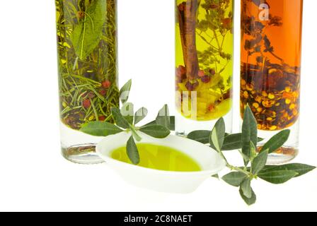 Olivenöl Schüssel Teller mit Olivenzweig und Gewürze & Kräuter auf dem Hintergrund. Natives Olivenöl. Natürliches Olivenöl, gesunde Ernährung. Stockfoto