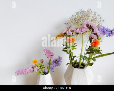 Kleiner Blumenstrauß aus wilden Frühlingsblumen in Vasen aus faux Marmor Stockfoto