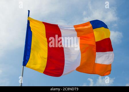 Mehrfarbige buddhistische Flagge (Symbol des Buddhismus) Nahaufnahme auf einem Himmelshintergrund. Sri Lanka Stockfoto