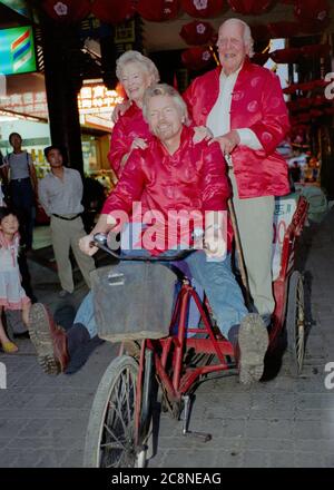 Sir Richard Branson, Gründer der Virgin Group, einschließlich Virgin Atlantic Airlines, mit seinen Eltern Ted und Eve, radeln durch die Straßen von Shanghai und feiern im Juli 1999 den ersten Flug der Airlines von Heathrow in die chinesische Stadt. Stockfoto