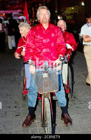 Sir Richard Branson Gründer der Virgin Group, einschließlich Virgin Atlantic Airlines mit seinen Eltern Ted und Eve, radeln durch die Straßen von Shanghai und feiern im Juli 1999 den ersten Flug der Airlines von Heathrow in die chinesische Stadt. Stockfoto