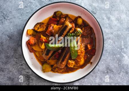 Gesunde pflanzliche Rezeptur Konzept, Tomatenkartoffel und Schneeerbsen braten mit veganen Würsten Stockfoto