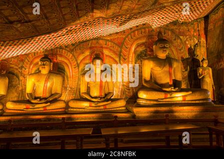 Drei alte Skulpturen eines sitzenden Buddha im buddhistischen Höhlentempel Rangiri Dambulu Raja Maha Viharaya. Dambulla, Sri Lanka Stockfoto