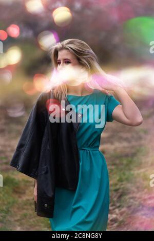 Schönes Mädchen mit funkelt Lichter auf ihrem Gesicht. Glückliche emotionale Frau genießen das Leben. Schönes Mädchen in bunten hellen Lichtern Stockfoto