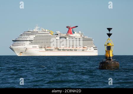 Das Kreuzfahrtschiff Carnival Breeze vor der Küste von Süd-Devon während des Coronavirus Ausbruch mit einer südlichen Kardinal Boje rechts davon verankert. D Stockfoto