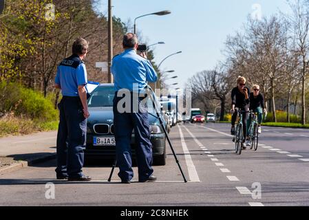 Polizeibeamte kontrollieren die Geschwindigkeit mit einer Laserpistole, Geschwindigkeitskontrolle, zwei Polizisten machen eine Geschwindigkeitskontrolle Stockfoto